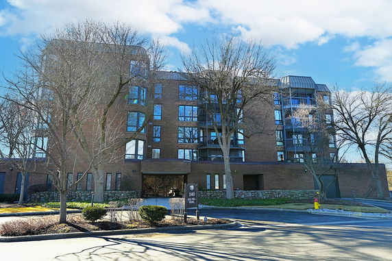 Front view of a multi-story brick building with large windows.