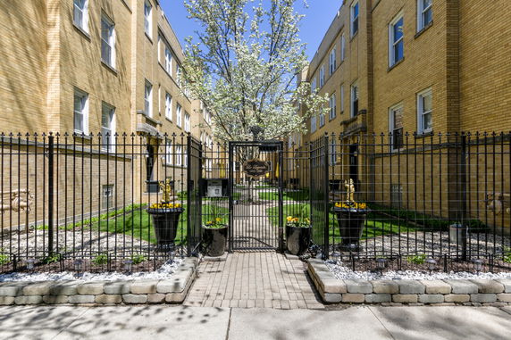 Front view of a brick residential building with a gated entrance.
