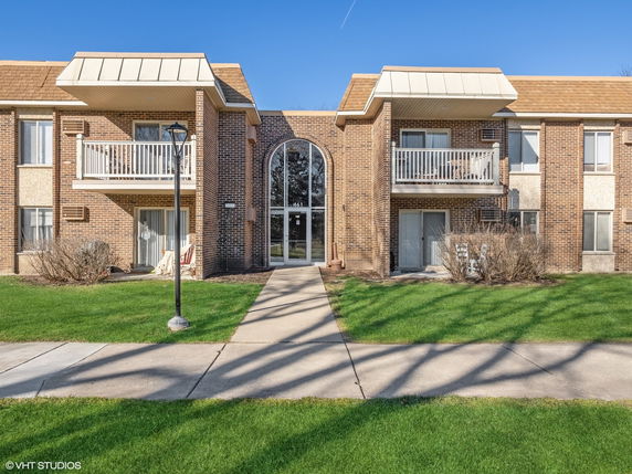 Front view of a two-story apartment building with balconies and brick exterior.