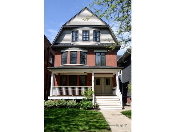 Front view of a two-story house with a gabled roof and a covered porch.