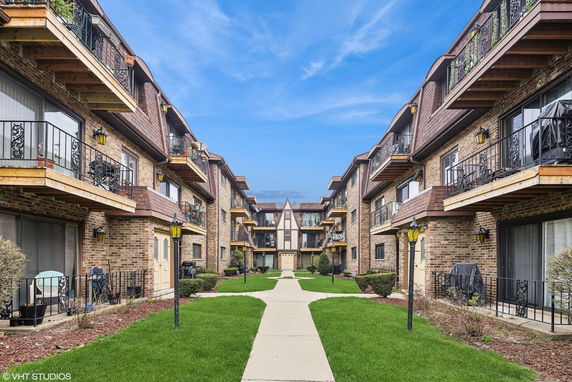 Front view of a multi-story apartment building with balconies.