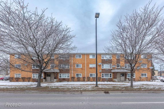 Front view of a three-story apartment building with a brick exterior.