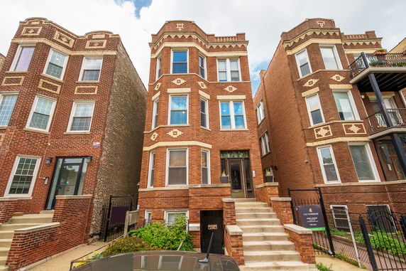 Front view of a multi-story brick building with decorative patterns.