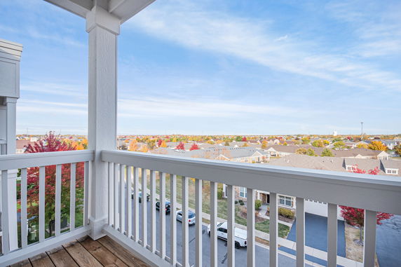 View from a balcony overlooking a suburban neighborhood with colorful trees and houses.