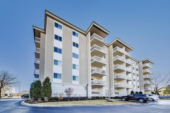 Front view of a multi-story apartment building with balconies.