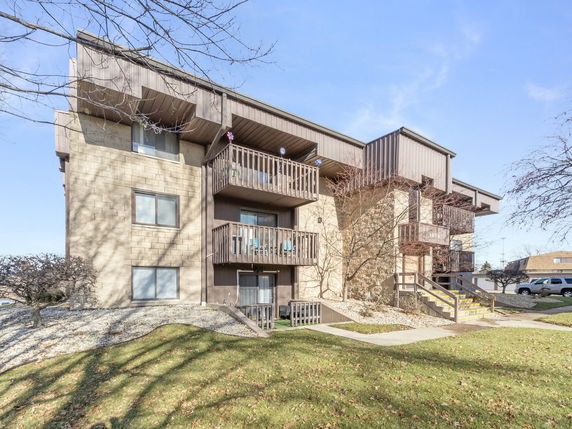 Front view of a multi-story apartment building with balconies.