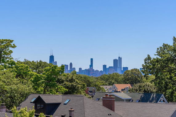 Panoramic view of a city skyline with buildings and trees in the foreground.