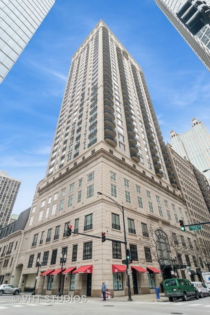 Front view of a tall multi-story building with balconies and large windows.