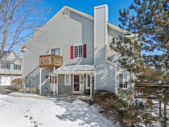 Front view of a two-story house with a small balcony and a chimney.