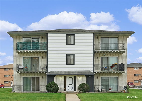 Front view of a multi-story apartment building with balconies.