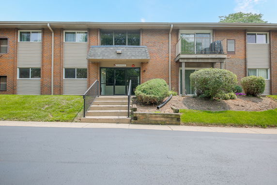 Front view of a brick multi-unit residential building with a central entryway.