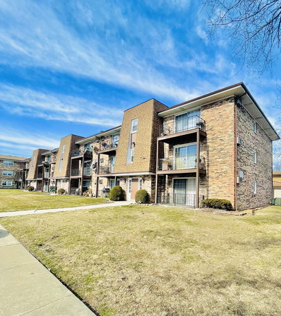 Front view of a multi-story apartment building with balconies.