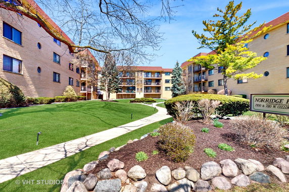 Front view of an apartment building with a landscaped garden.