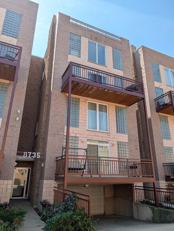 Front view of a multi-story residential building with balconies.