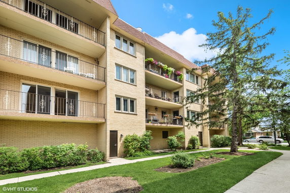 Front view of a multi-story apartment building with balconies.