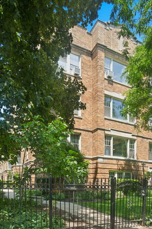 Front view of a multi-story brick building with large windows.