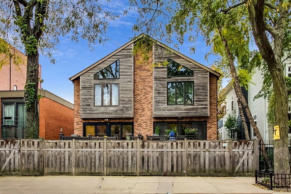 Front view of a two-story house with wooden and brick exterior.
