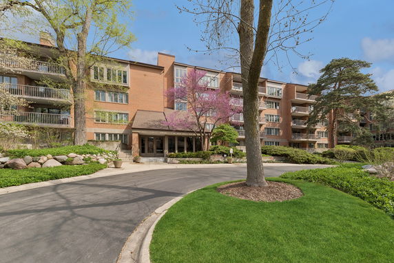 Front view of a multi-story brick apartment building with balconies.