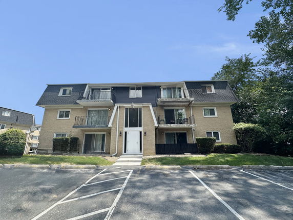 Front view of a three-story apartment building with balconies.