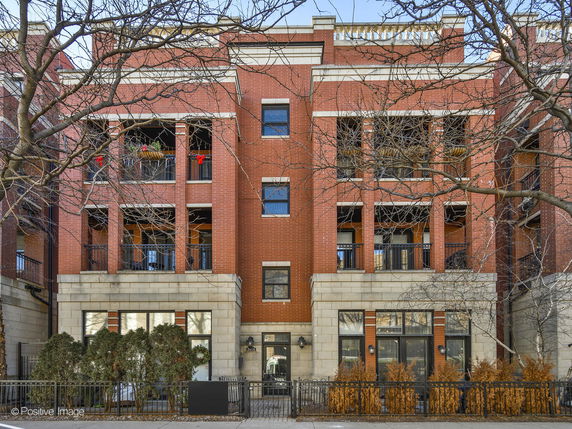 Front view of a multi-story brick building with balconies.