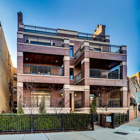 Front view of a multi-story brick building with balconies.