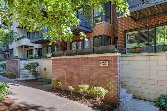 Front view of a multi-story residential building with brick exterior and balconies.