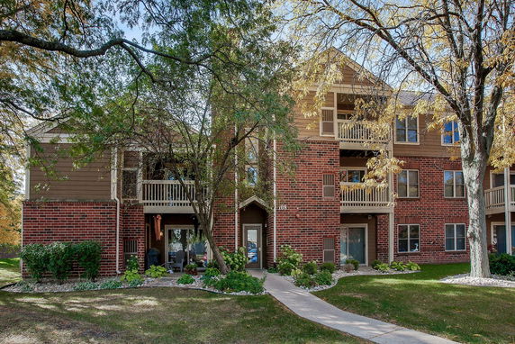 Front view of a multi-story brick apartment building with balconies.