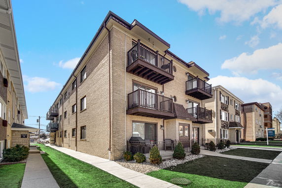 Front view of a three-story apartment building with balconies.