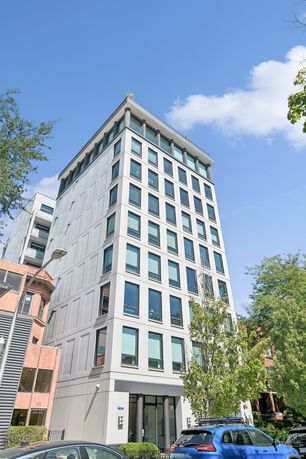 Front view of a multi-story building with large windows and modern architecture.