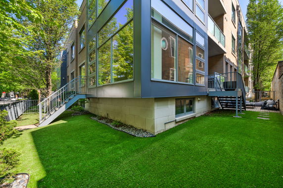 Side view of a modern multi-story building with large windows and an external staircase.
