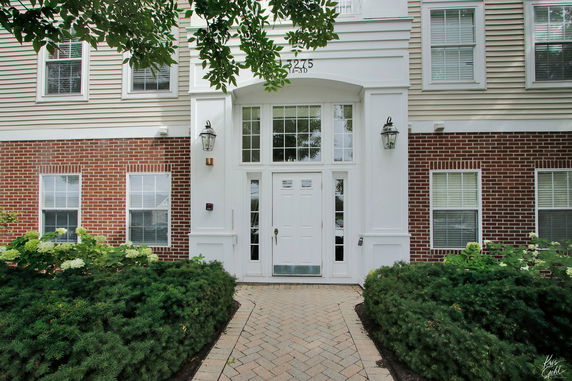 Front view of a multi-story building with a central entrance and brick facade.