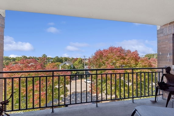 Balcony view overlooking trees and residential area.