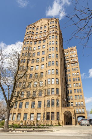 Front view of a tall, multi-story brick building with numerous windows.