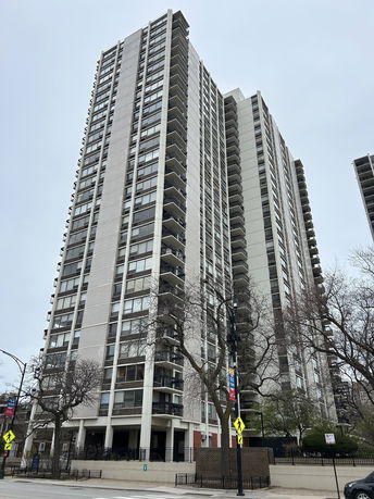 Front view of a high-rise apartment building with multiple balconies.