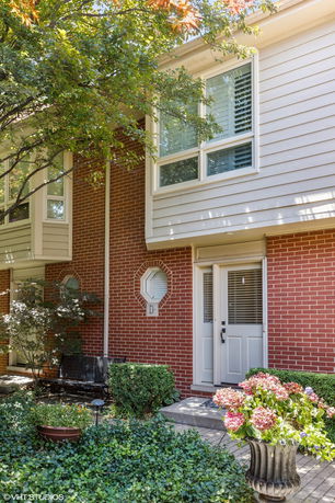 Front view of a two-story residential building with brick and siding exterior.