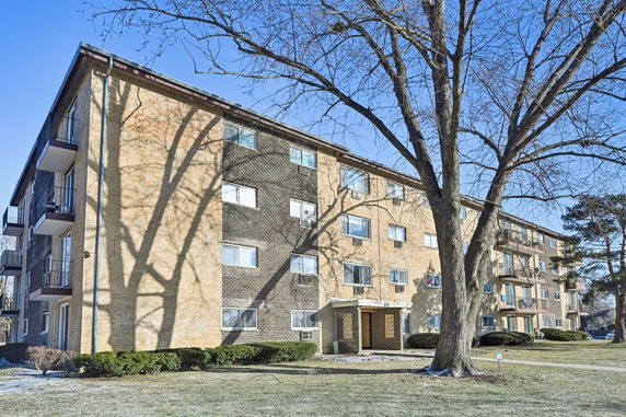 Front view of a multi-story apartment building with balconies.