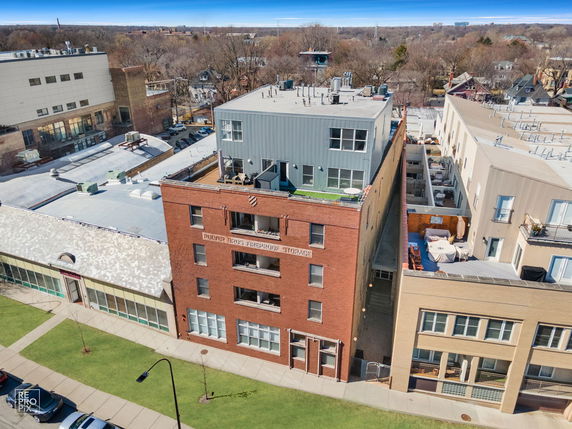 Front view of a multi-story brick building with rooftop units.