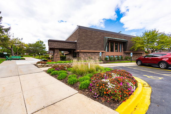 Front view of a brick building with a modern design and a small landscaped area.