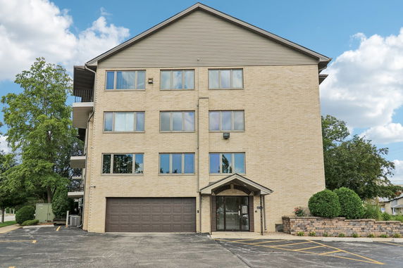 Front view of a multi-story building with a garage and entrance.