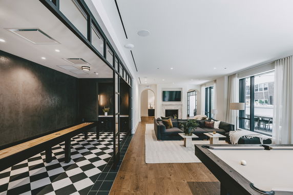 Interior view of a recreation room with a pool table and a sitting area.