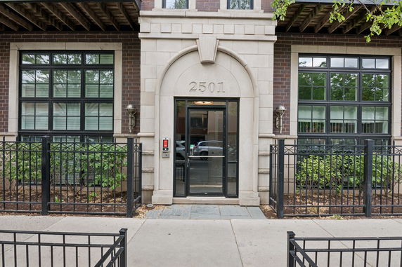 Front view of a building entrance with a glass door and two windows.