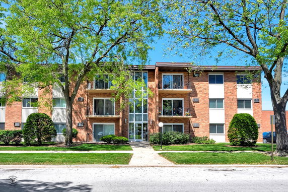 Front view of a three-story apartment building with balconies.