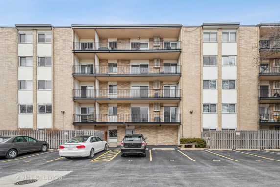 Front view of a multi-story apartment building with balconies.