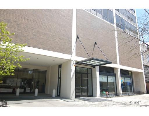 Front view of a multi-story building with a glass entrance canopy.