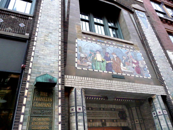 Front view of a building with intricate tile work and an entrance sign for The Franklin Company.