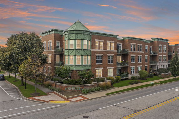 Front view of a three-story brick building with green accents.