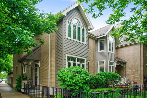 Front view of a two-story house with a narrow front yard and a small porch.