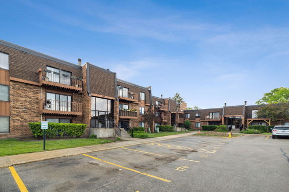 Front view of a multi-story apartment building with brick exterior and balconies.