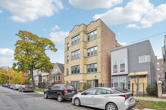Front view of a multi-story residential building with brick facade.
