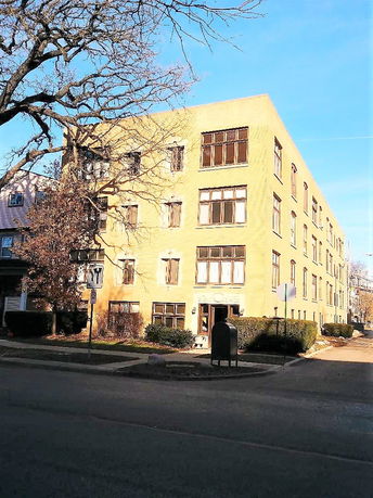 Front view of a multi-story brick apartment building.